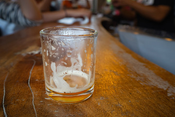 Glass for testing beer on wooden table.