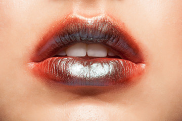 Fototapeta premium Close up view of beautiful woman lips with orange lipstick.