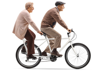 Naklejka premium Senior man and woman riding a tandem bicycle