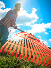 Unusual angle of woman raking leaves