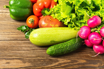Fresh vegetables bunch greens on wooden background. Vegetarianism is a healthy lifestyle. Flat layout. View from above
