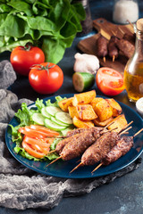 Grilled shish kebab served with fried potatoes