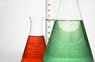 Laboratory Flask. Closeup Of Different Laboratory Glassware With Color Liquid Against White Background.
