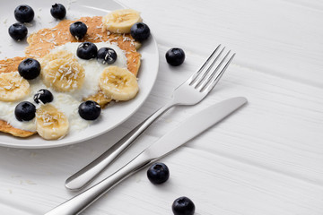 Sweet oatmeal pancakes with cream, blueberry and banana. Healthy Breakfast concept.