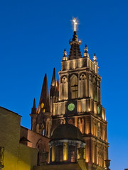 Fototapeta na wymiar Side view of La Parroquia de San Miguel Arcangel and clock tower lit in the Blue Hour
