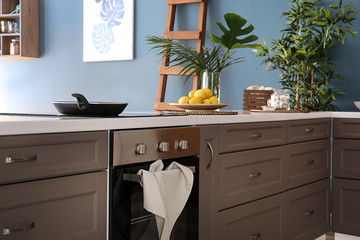 Modern furniture with electric stove in kitchen