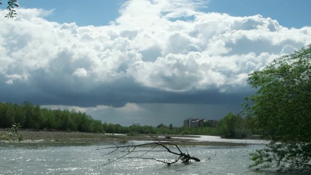 Watercourse of the mountain river after heavy rains against the background of the blue sky and white clouds, background