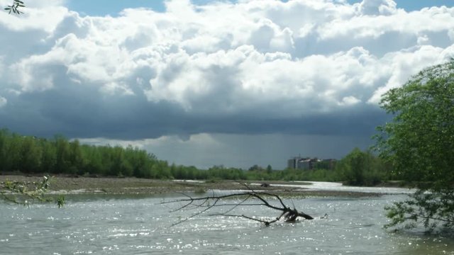 Watercourse of the mountain river after heavy rains against the background of the blue sky and white clouds, background, time lapse