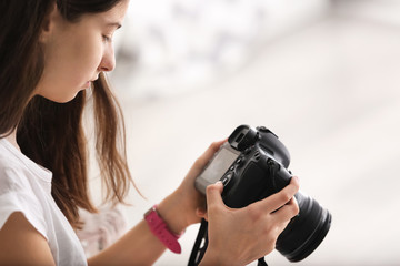 Young girl with modern photo camera at home