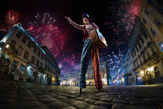 Night street circus performance whit clown. Festival city background. fireworks and Celebration atmosphere. Wide engle photo