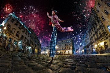 Night street circus performance whit clown. Festival city background. fireworks and Celebration...