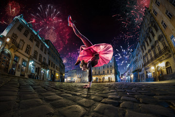 Night street circus performance whit flexible girl, juggler. Festival city background. fireworks...