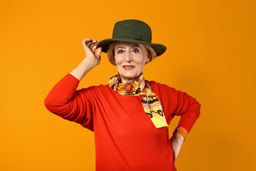 Stylish mature woman on color background