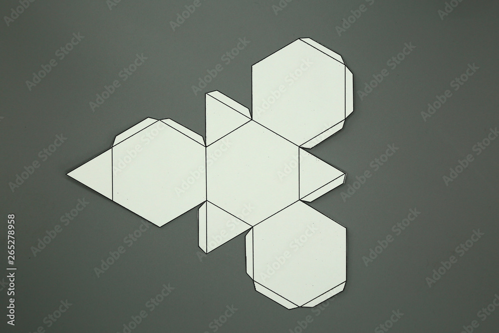 Wall mural Geometric shape cut out of paper and photographed from above on grey background.Geometry net of Truncated tetrahedron. Unfolded three Dimensional Figures. Isolated. Top view.