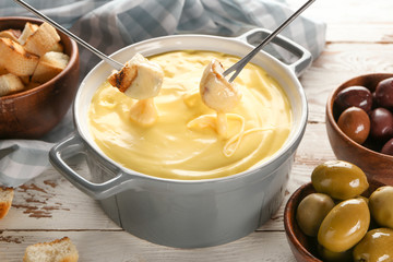 Cheese fondue with snacks on table