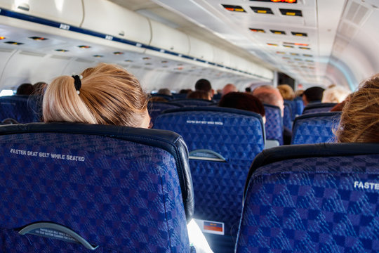 Interior Of The Airplane With Passengers On Seats