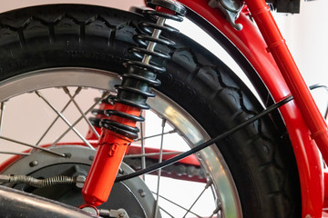 Rear wheel and suspension of a red vintage motor bike