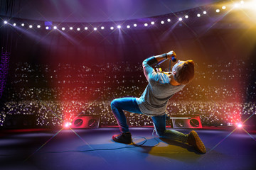 Rock star celebrity on the main stage big music festival. Aroun full stadium of spectators. fans...