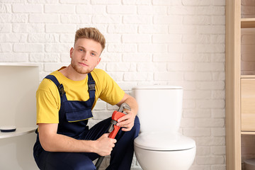 Handsome young plumber in restroom