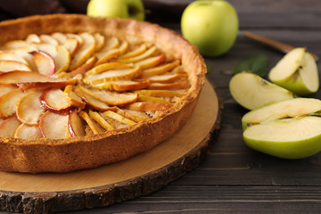 Tasty apple pie on wooden table, closeup