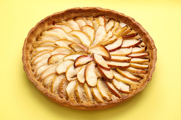 Tasty apple pie on color background
