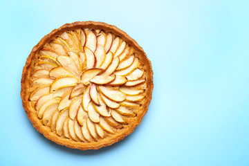 Tasty apple pie on color background