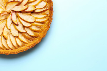 Tasty apple pie on color background