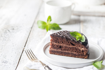 Delicious chocolate Prague cake on plate over white background