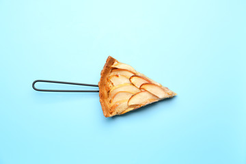Piece of tasty apple pie on color background