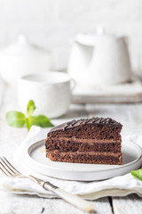 Delicious chocolate Prague cake on plate over white background