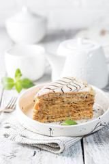 Traditional Hungarian Esterhazy piece of cake on a white wooden background.