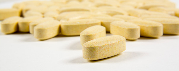 Pills scattered on a gray background. The photo shows vitamins for hair growth