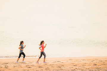 Fototapeta na wymiar Portrait beautiful young sport asian woman running and exercise on the beach near sea and ocean at sunrise or sunset time