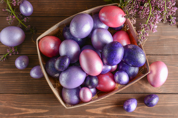 Box with beautiful Easter eggs on wooden background