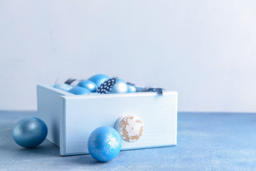 Box with beautiful Easter eggs on table