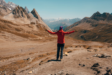 Naklejka premium tourist with raised hands standing at mountain pass Col de la Seigne.