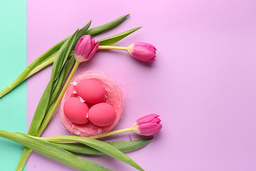 Beautiful Easter eggs with flowers on color background