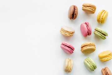 Brignt macarons for sweet break on white background top view mock up