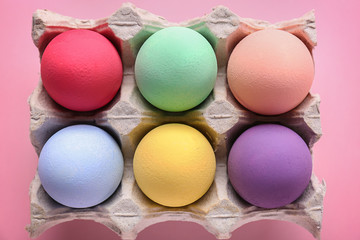 Package with beautiful Easter eggs on color background