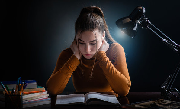 Young beautiful but stressed student girl studying for hard exam