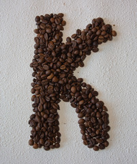 Image of roasted coffee beans shaped alphabet on a white background