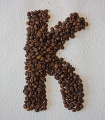 Image of roasted coffee beans shaped alphabet on a white background