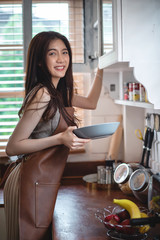 Young attractive Asian woman preparing food in the kitchen in the morning 