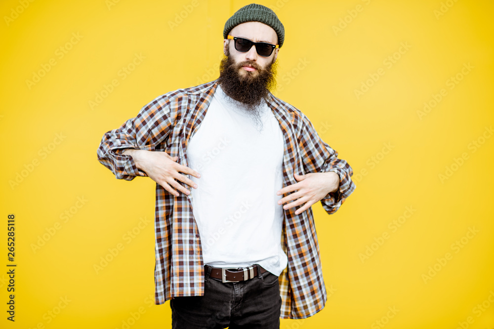 Canvas Prints Portrait of a cool stylish man in shirt and hat posing on the bright yellow background