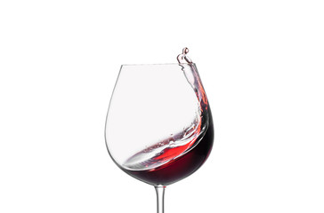 Splashing red wine in a glass on a white background