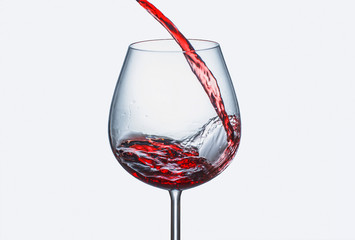 Pouring red wine in a glass with splashes