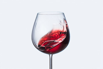Splashes of red wine in a glass goblet