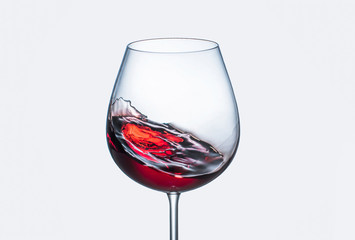 Splashes of red wine in a glass goblet