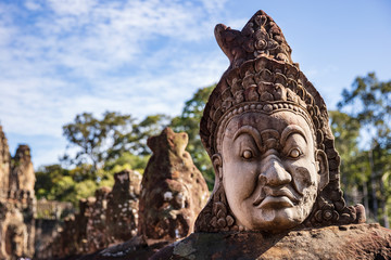 Head sculptures on the bridge leading to the south gate at Angkor Thom temple complex, Siem Reap,...