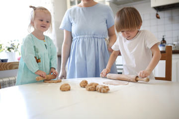 mother cooks with her children,siblings make cakes